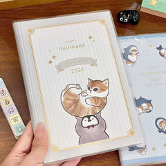 Hand holding a cute B6 weekly planner with a premium protective cover and pastel artwork