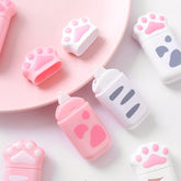 Pink and white cat paw correction tape dispensers with caps removed