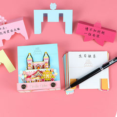 Layered castle note pad with writing sheets and pen on a pink desk