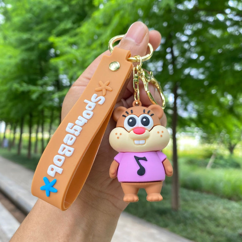 Brown squirrel character keychain with purple outfit and soft rubber pendant