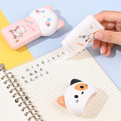 Cat design correction tape dispenser applying tape to a notebook