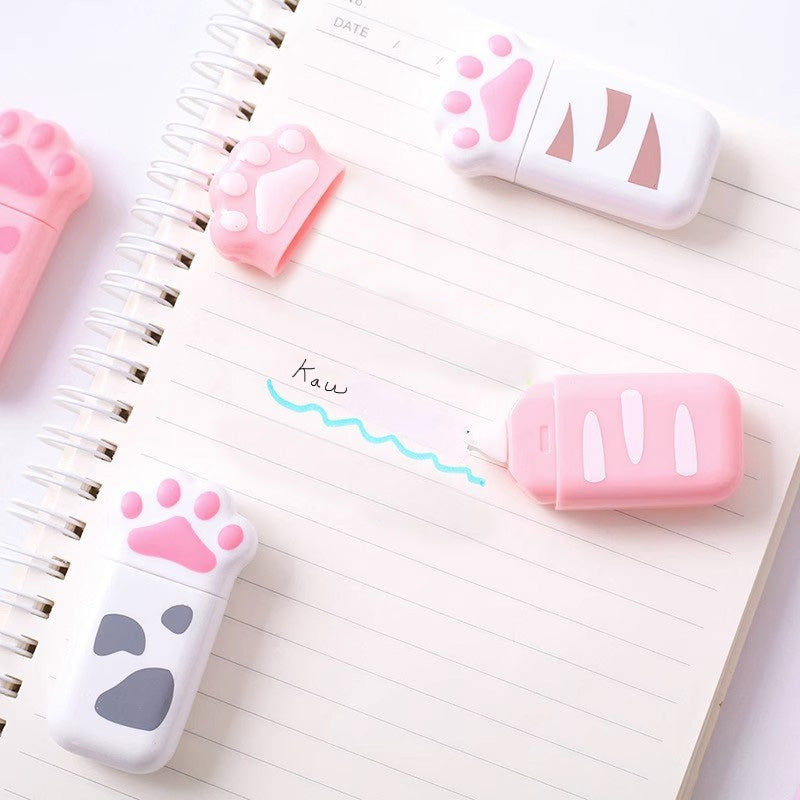Cat paw correction tape dispenser used on a notebook page