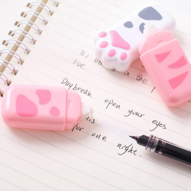 Cat paw correction tape dispensers on a notebook