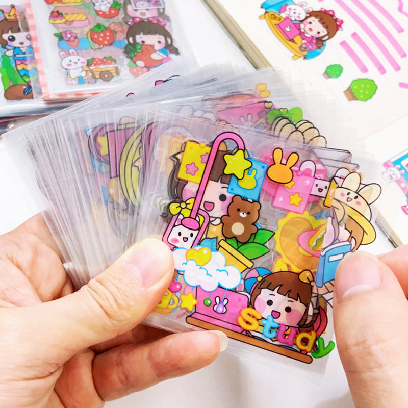 Close up of clear PET sticker sheets with colorful cartoon designs for decorating planners, notebooks, water bottles, and crafts