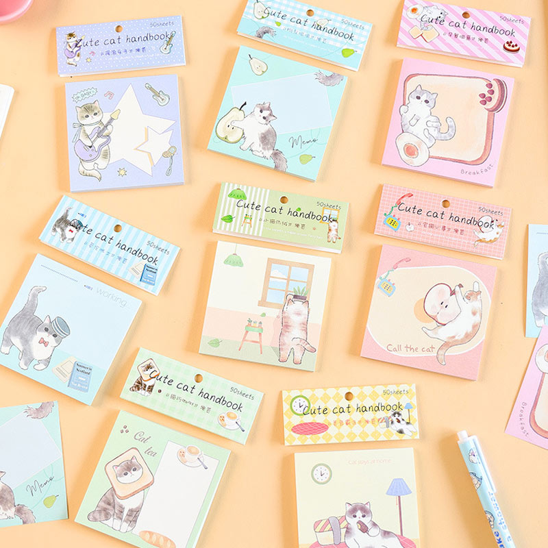 Pastel cute cat handbook notebooks arranged on a peach background