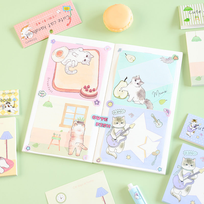 Open cute cat notebook showing four colorful cartoon message designs