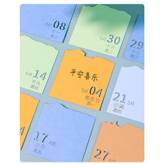 Colorful calendar note cards displayed beside a 3D paper landscape