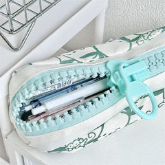 Partially opened large zipper pencil case showing easy access to pens through the oversized zipper opening