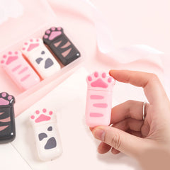 Pink cat paw correction tape dispenser held in hand