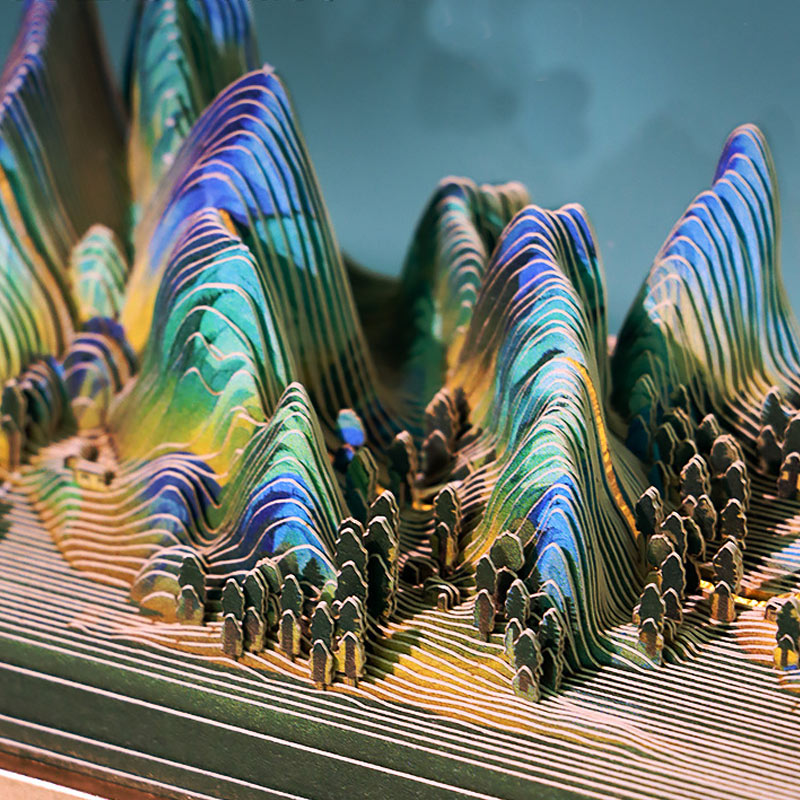 Close-up of layered Chinese mountain paper sculpture with colorful scenic details