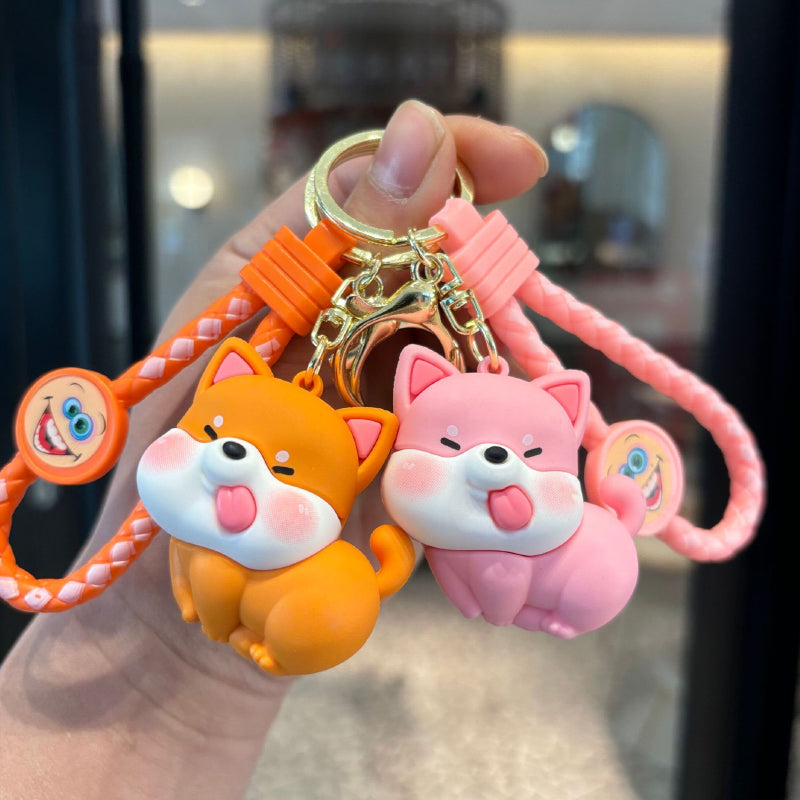 Orange and pink dog keychain pair with braided straps and metal rings