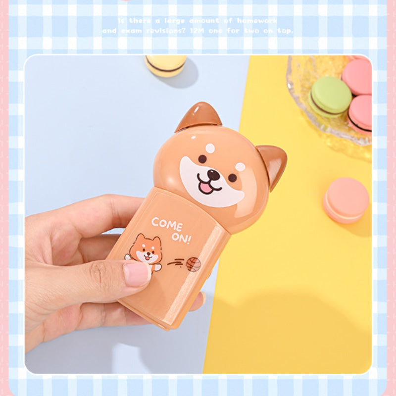 Orange puppy correction tape dispenser held in a hand