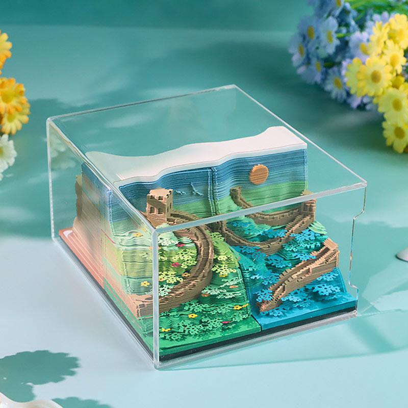 Detailed paper landscape sculpture showing green and blue seasonal scenery