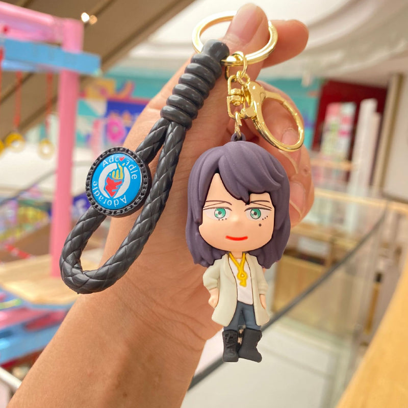 Purple-haired doll keychain with black braided strap and metal clasp