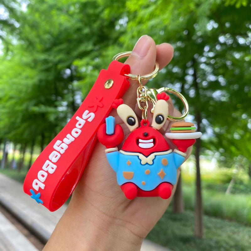 Red crab character keychain with blue outfit, burger detail and wrist strap