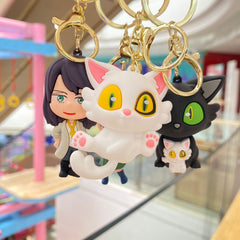 White and black cat keychain set with gold-tone rings and rubber pendants