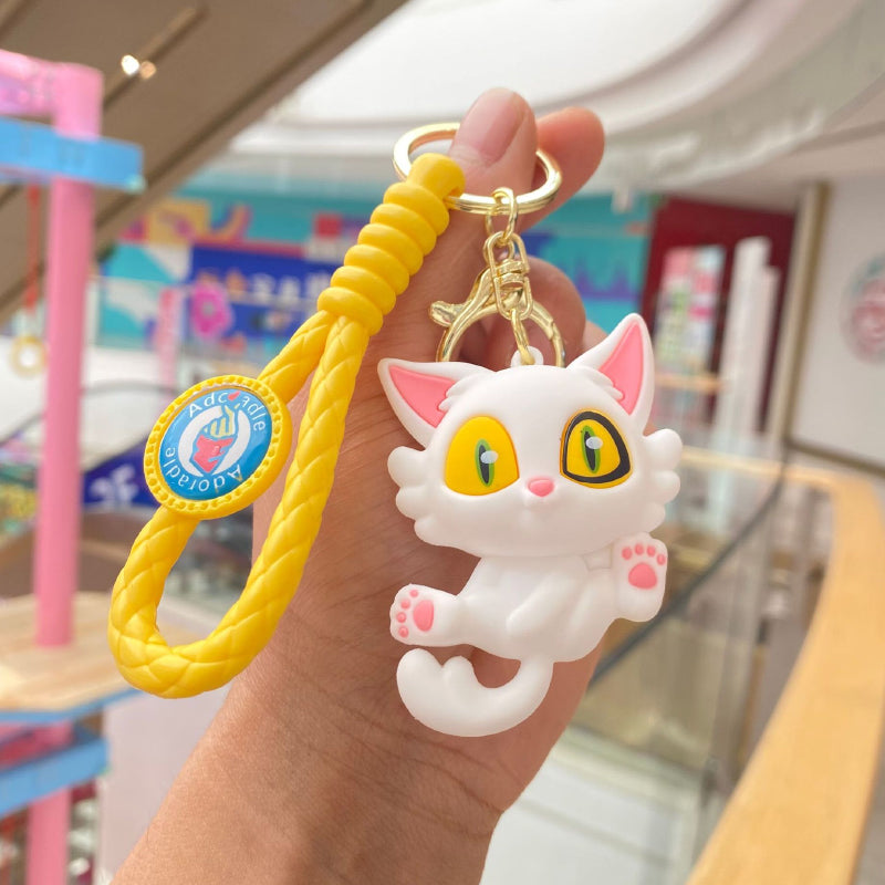 White cat rubber keychain with yellow braided strap and metal clasp